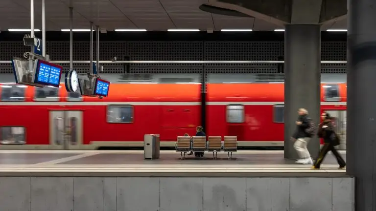 רכבת פרוורית אדומה חולפת ברציף תחנה עם נוסעים ממתינים - הדימוי של קו הצ'ירקומפלגריאה בנאפולי
