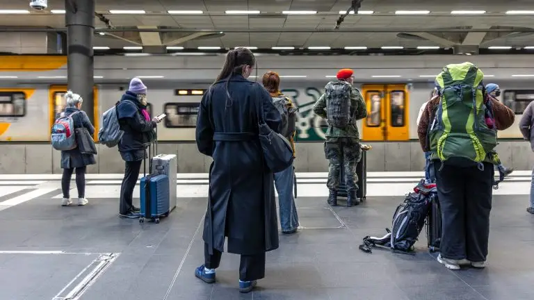מטיילים עם מזוודות ותיקים ממתינים על רציף תחנת רכבת - אחסון מזוודות בנאפולי
